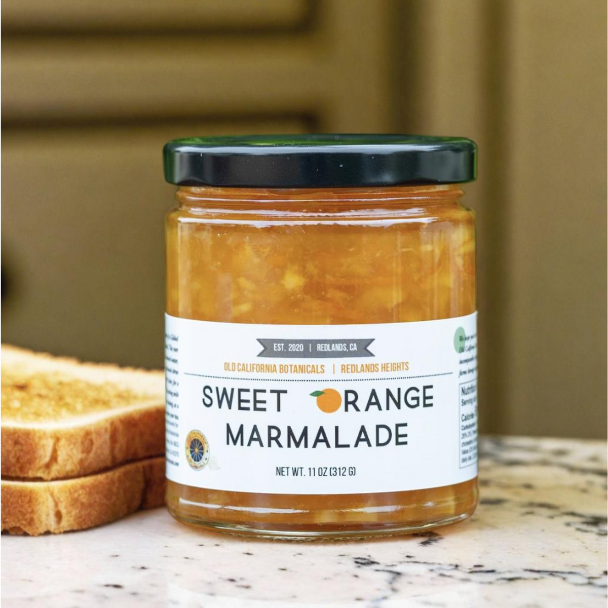 A jar of Old California Botanicals Navel Orange Marmalade beside toast