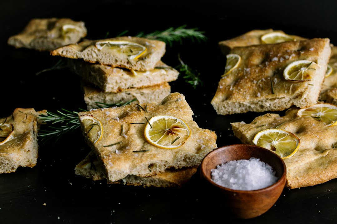 Brown bread with sliced lemon on black surface