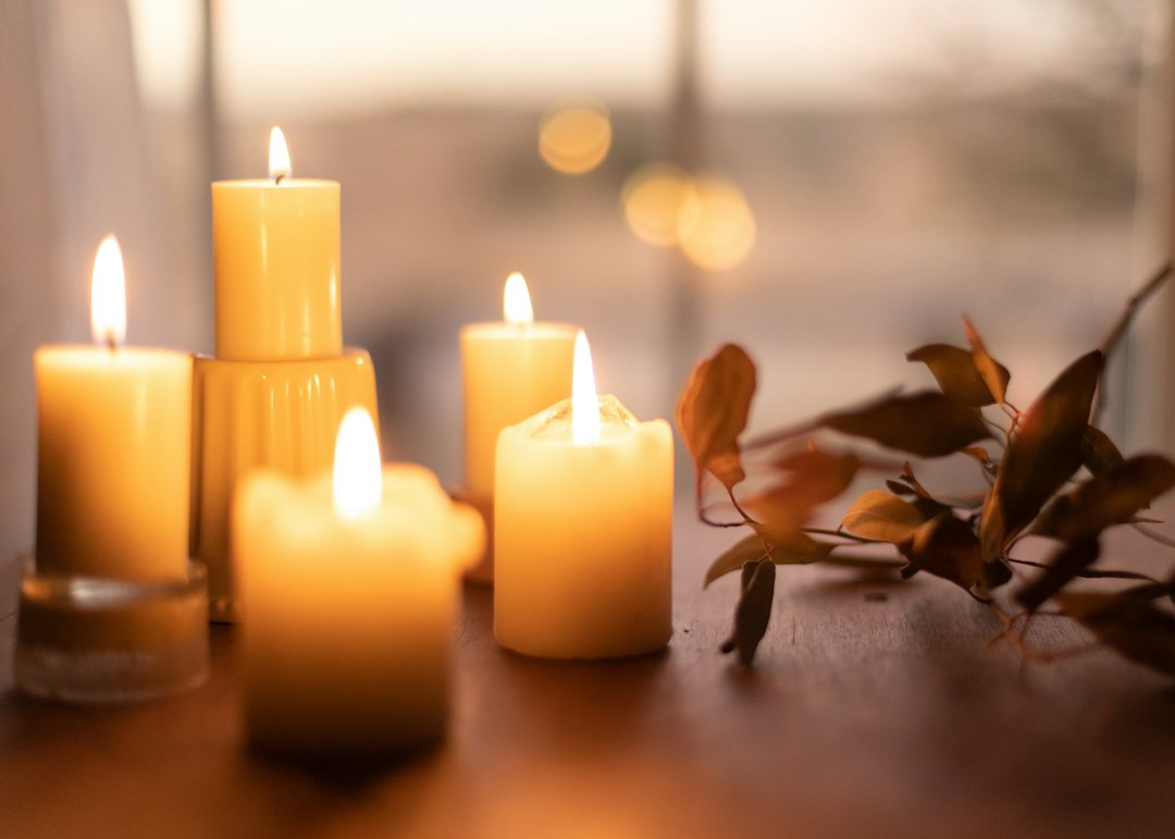 White pillar candles on brown wooden table