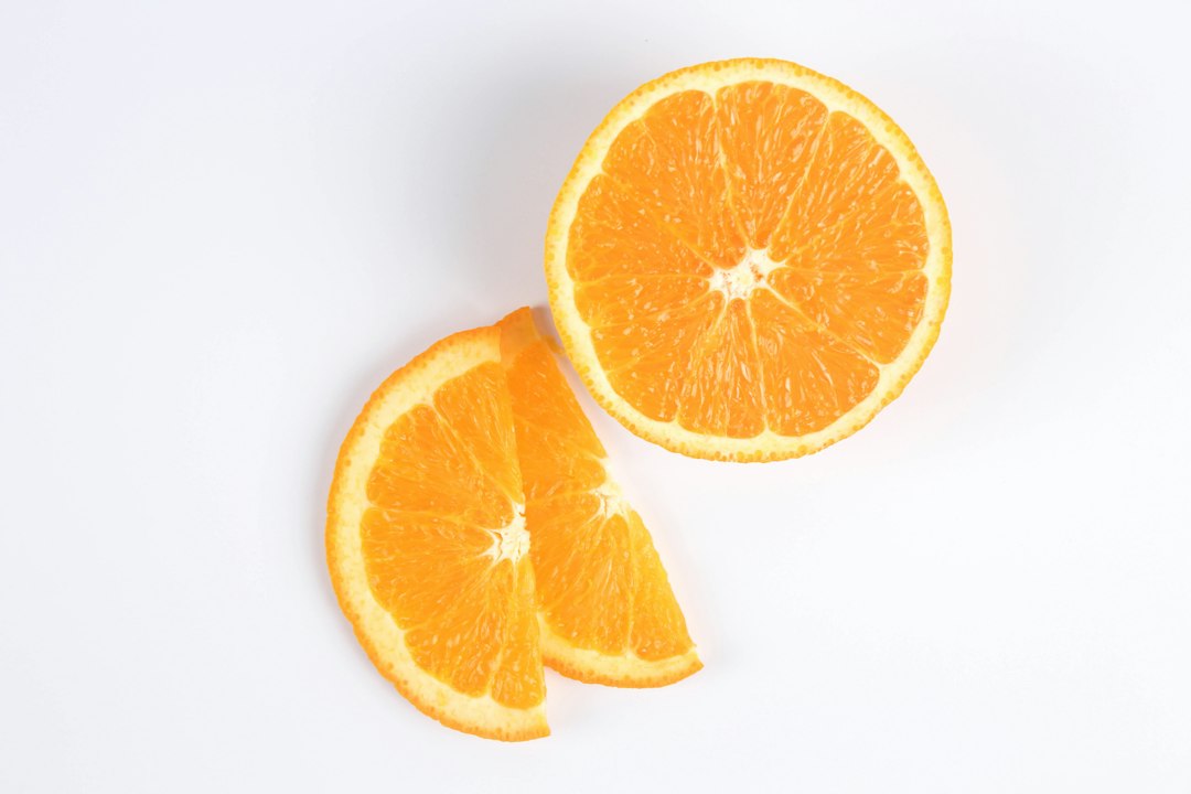 Sliced orange fruit on white surface