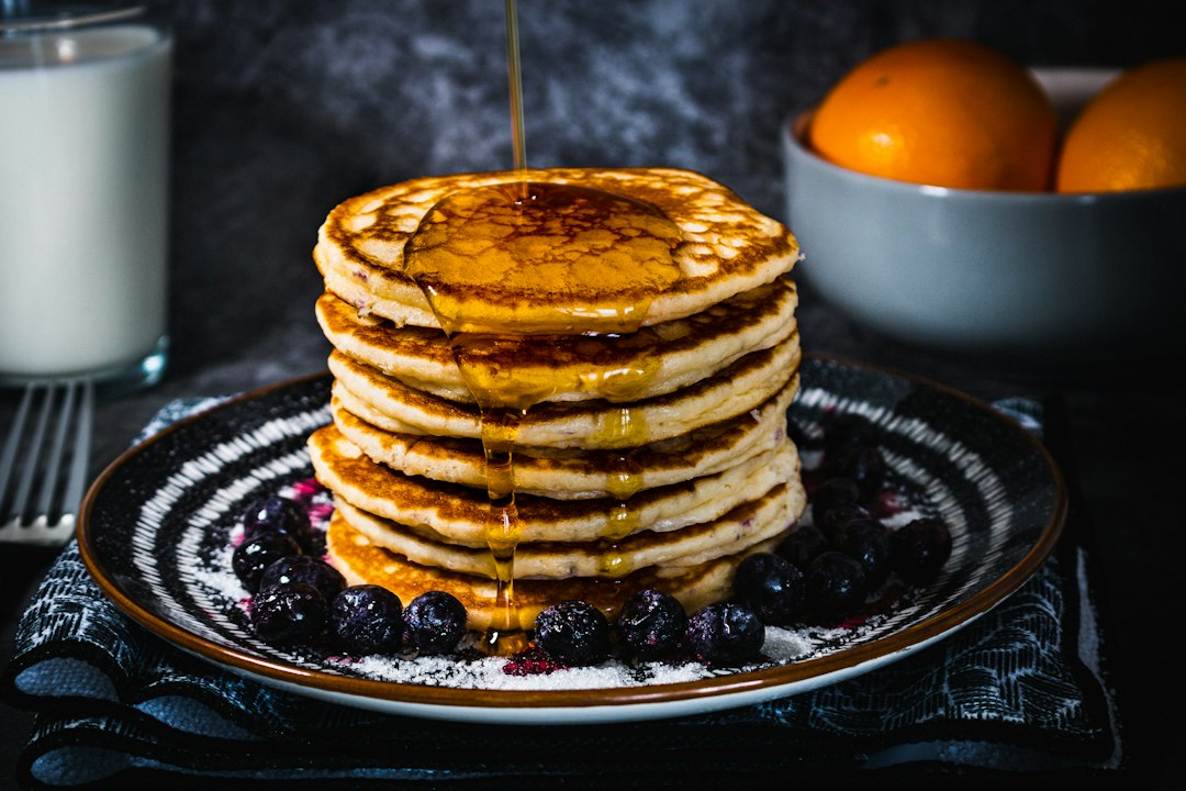 Pancakes with egg on black ceramic plate