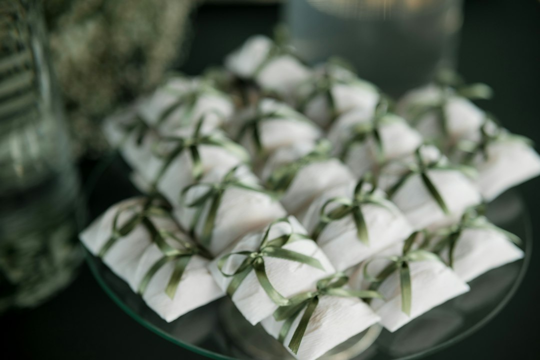 Small white gifts tied with green ribbon on a platter