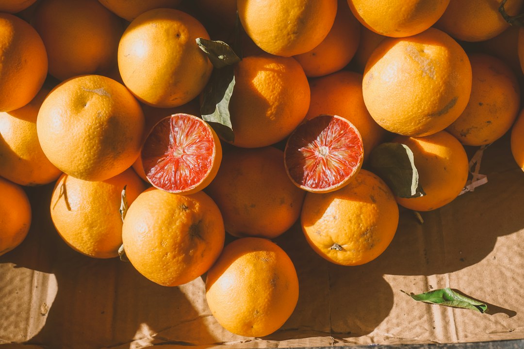 Fresh oranges and sliced blood oranges in a wooden crate