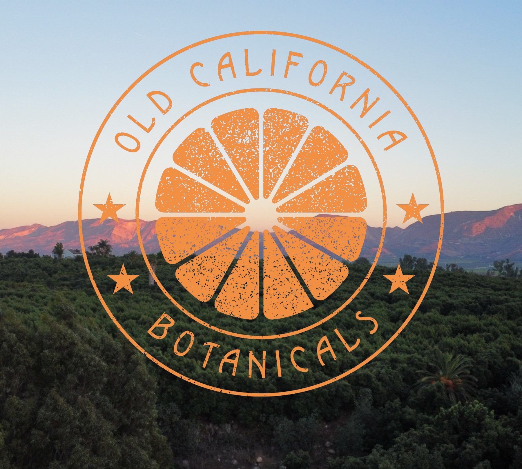 Old California Botanicals seal over the Redlands grove at sunset